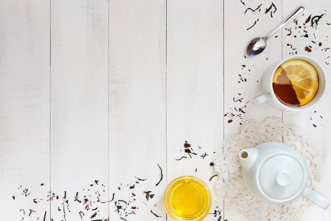 Taza de infusión de limón con miel y cuchara sobre una mesa