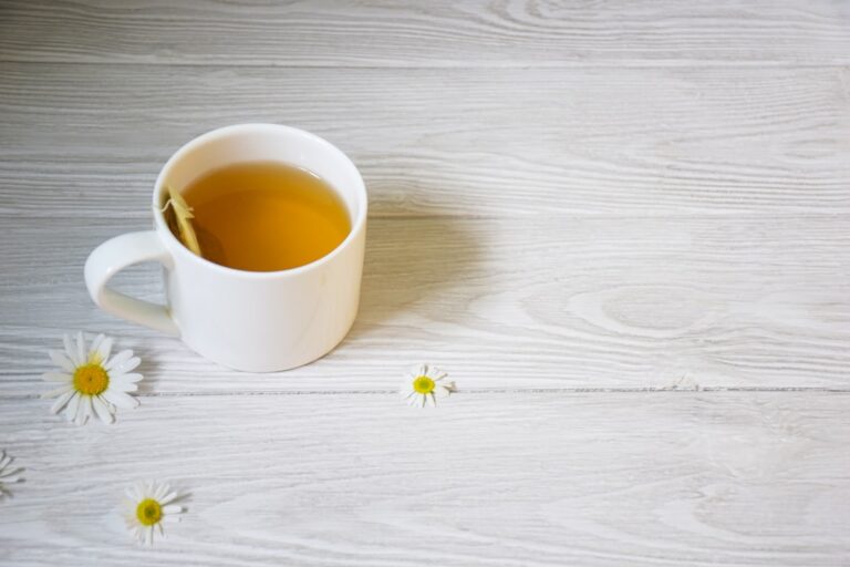 Taza de infusión de manzanilla servida para una rutina de descanso